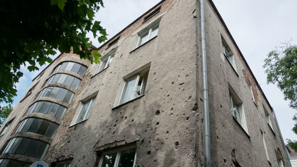 Ślady Powstania Warszawskiego w postaci podziurawionej fasady budynku przy ulicy Tenisowej 8 